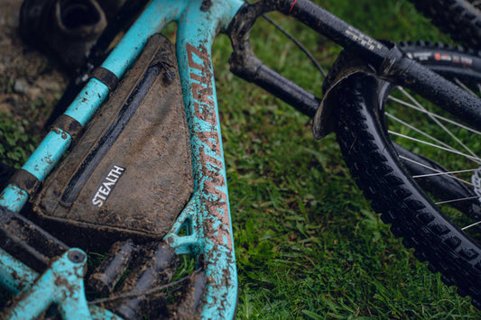 Stealth frame bag caked in mud on a wet full suspension MTB – water-resistant bikepacking gear, made by Stealth Wellington NZ