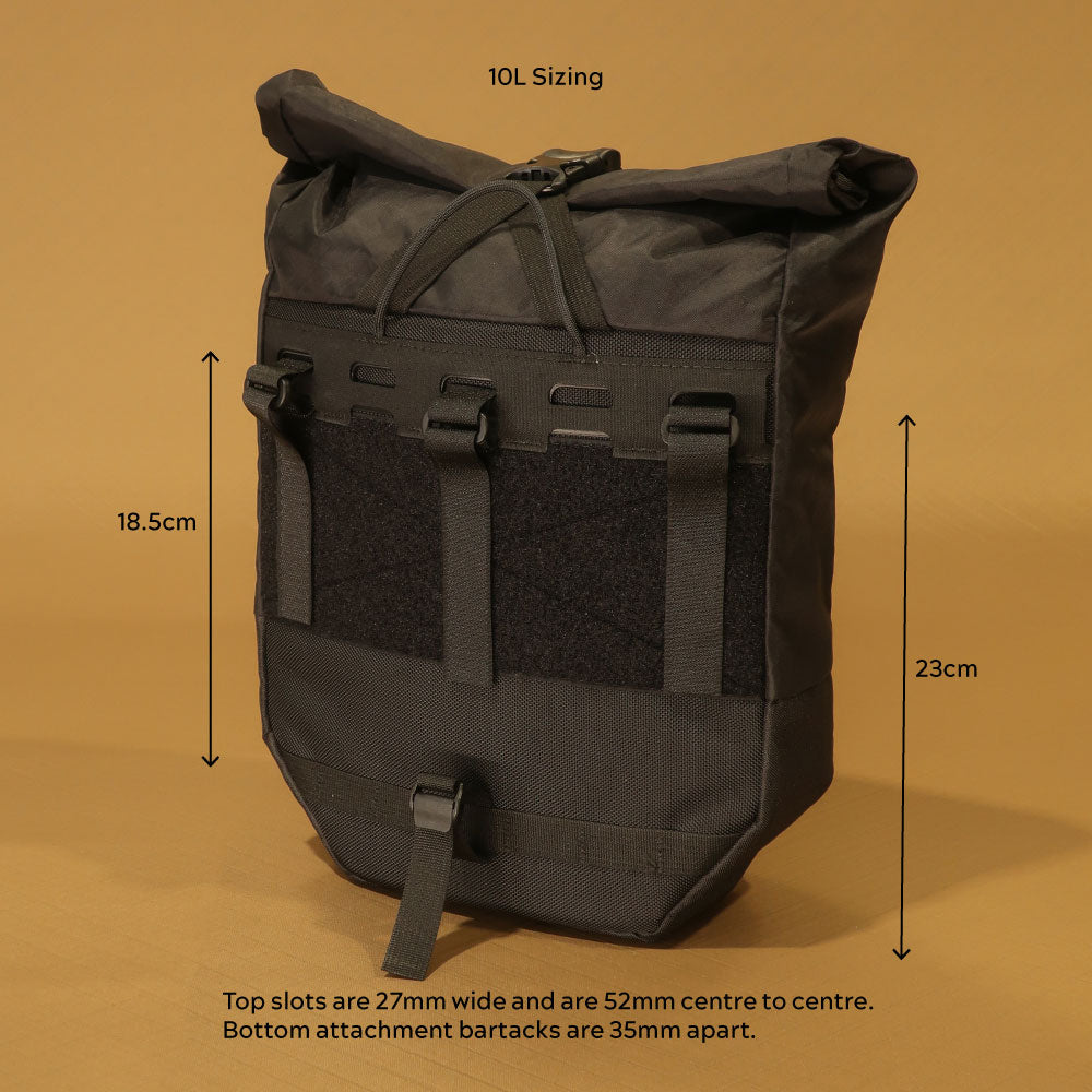 Rear view of 10L pannier with attachment dimensions labelled: 18.5cm upper strap zone, 23cm lower panel height, 27mm wide top slots spaced 52mm centre to centre, and 35mm bottom bartack spacing