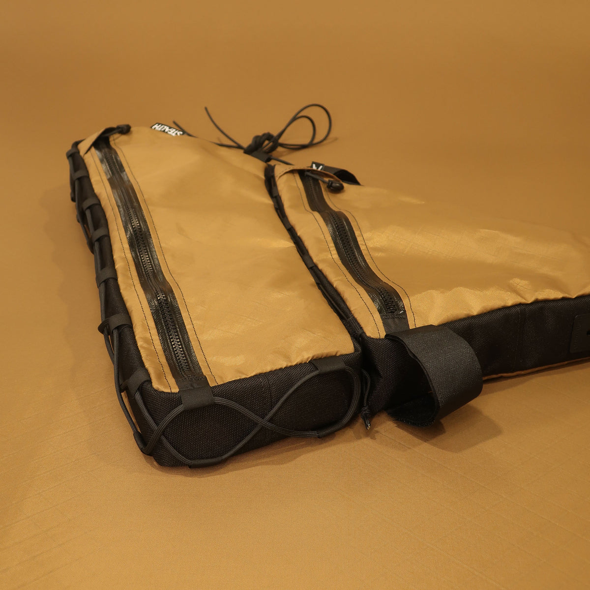 Custom Curve GMX full frame bag in tan with double zips, lace-up sides, and bolt-on attachments for bikepacking and cycling.