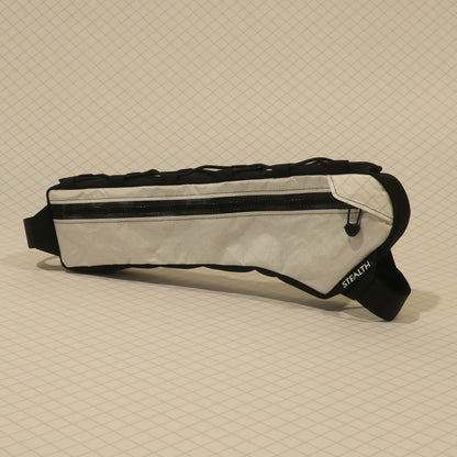 Half frame bag in light fabric with single zip, black trim, and strap, designed for gravel bikes