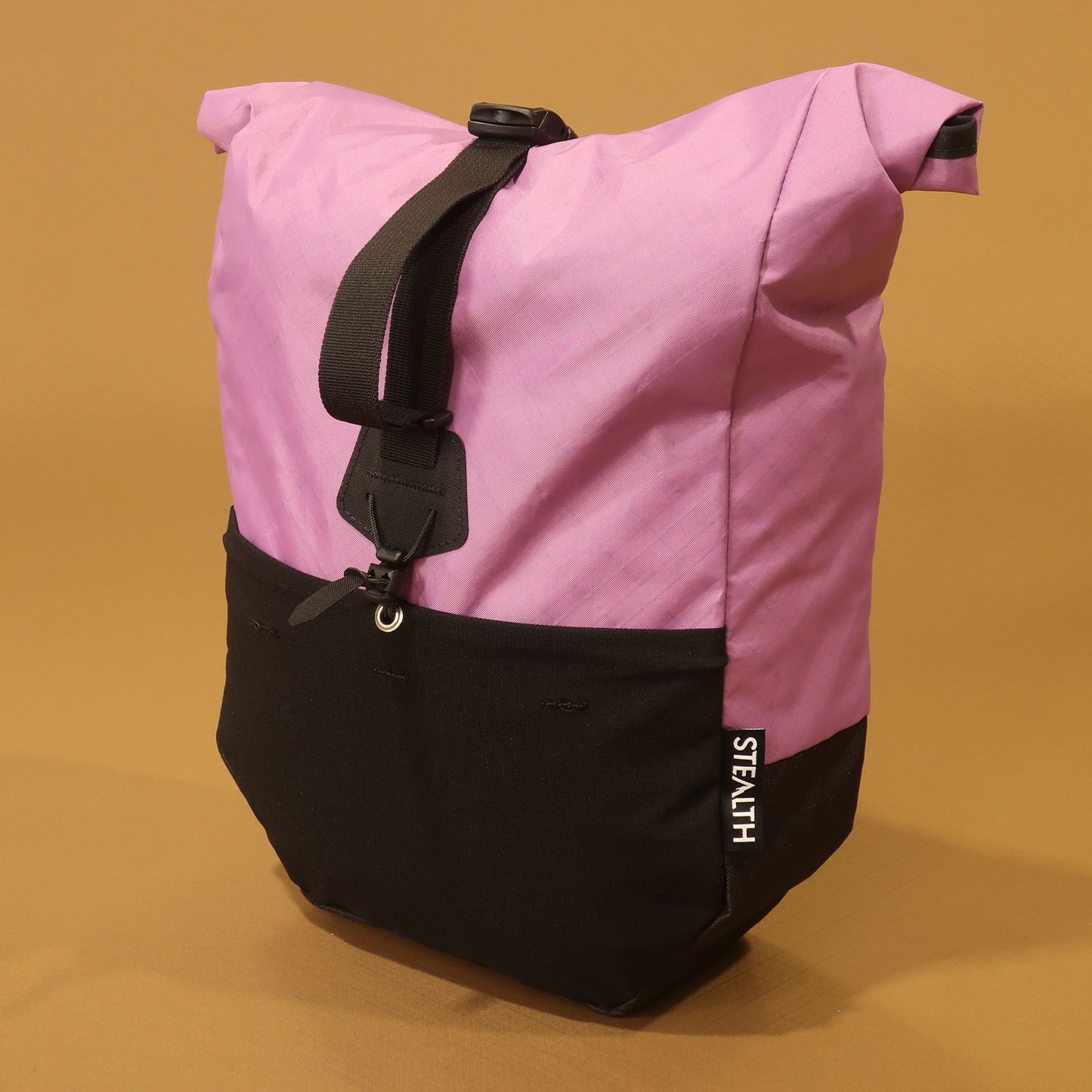 Lilac and black mountain bike pannier with roll top closure, front stretch pocket and adjustable attachment straps 
