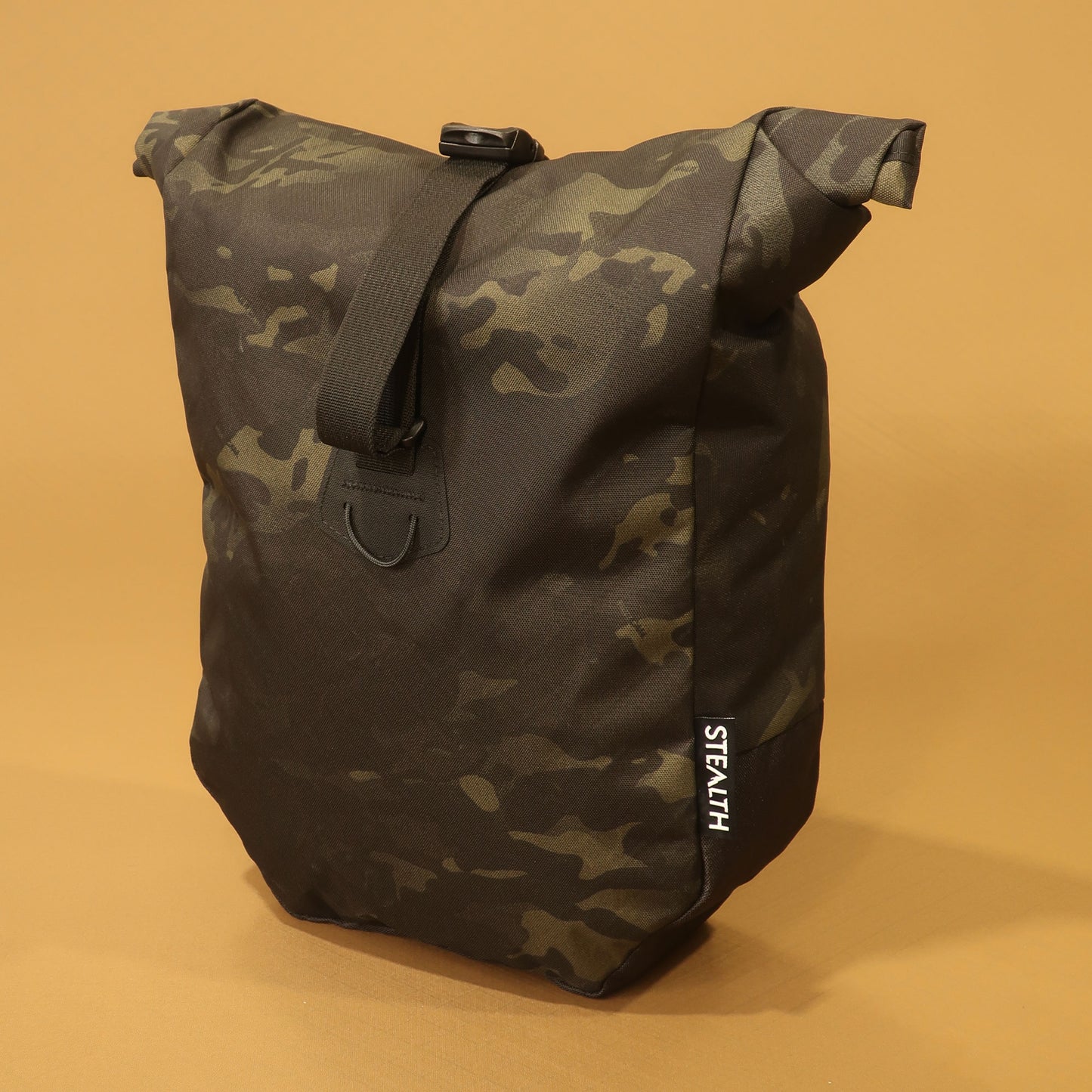 Multicam Black mountain pannier with a roll top and attachment straps for mountain biking and bikepacking