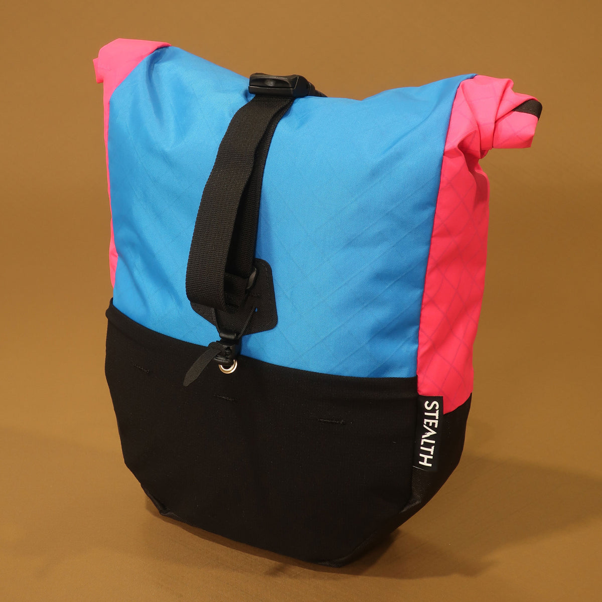 Blue, pink, and black mountain bike pannier with a roll top closure and stretch front pocket made in NZ