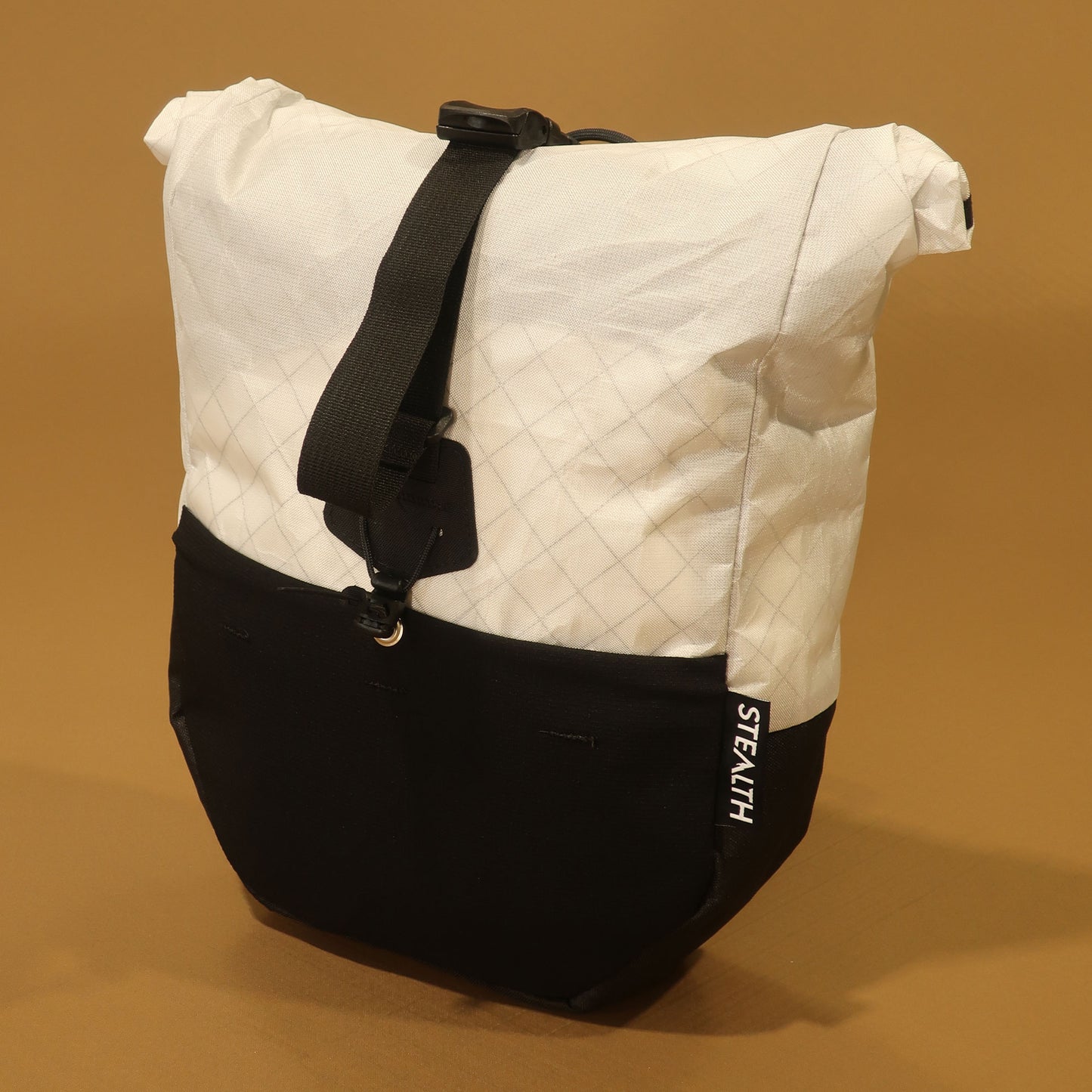 White Ultra200x mountain bike pannier with a roll top closure, stretch front pocket, and adjustable attachment straps for bikepacking.