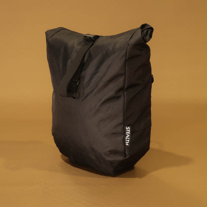 Front view of black 10L roll-top bicycle pannier with carry handle and roll-top buckle closure