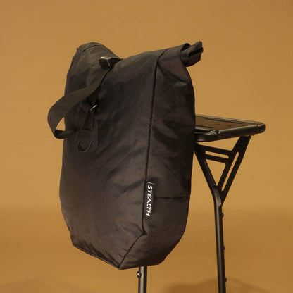 Front view of black 8L roll-top bicycle pannier with carry handle and roll-top closure buckle