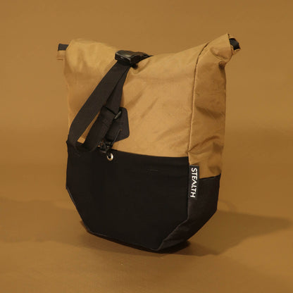 Front view of 8L roll-top bicycle pannier in coyote tan with black base, showing roll-top closure strap and Stealth logo label
