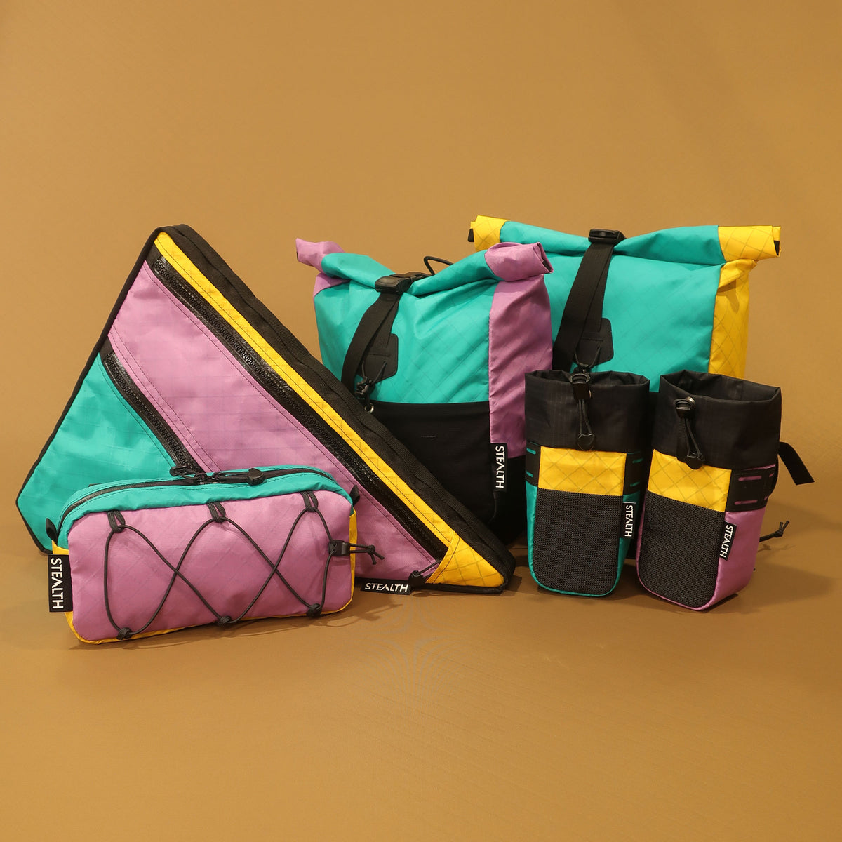 Multicolour handmade bikepacking bags, including a double zip full frame bag with secure attachment points, crafted in New Zealand for cyclists and adventurers.