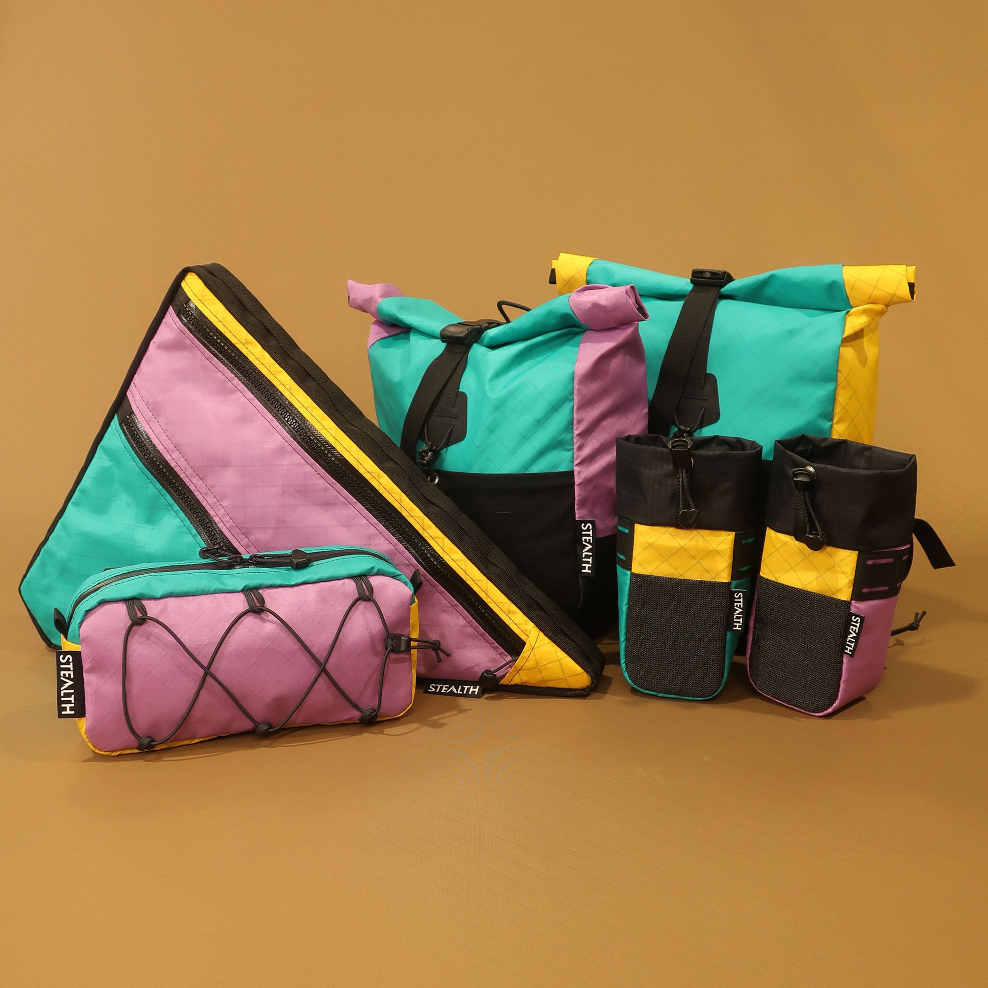 Multicolour handmade bikepacking bags, including a double zip full frame bag with secure attachment points, crafted in New Zealand for cyclists and adventurers.