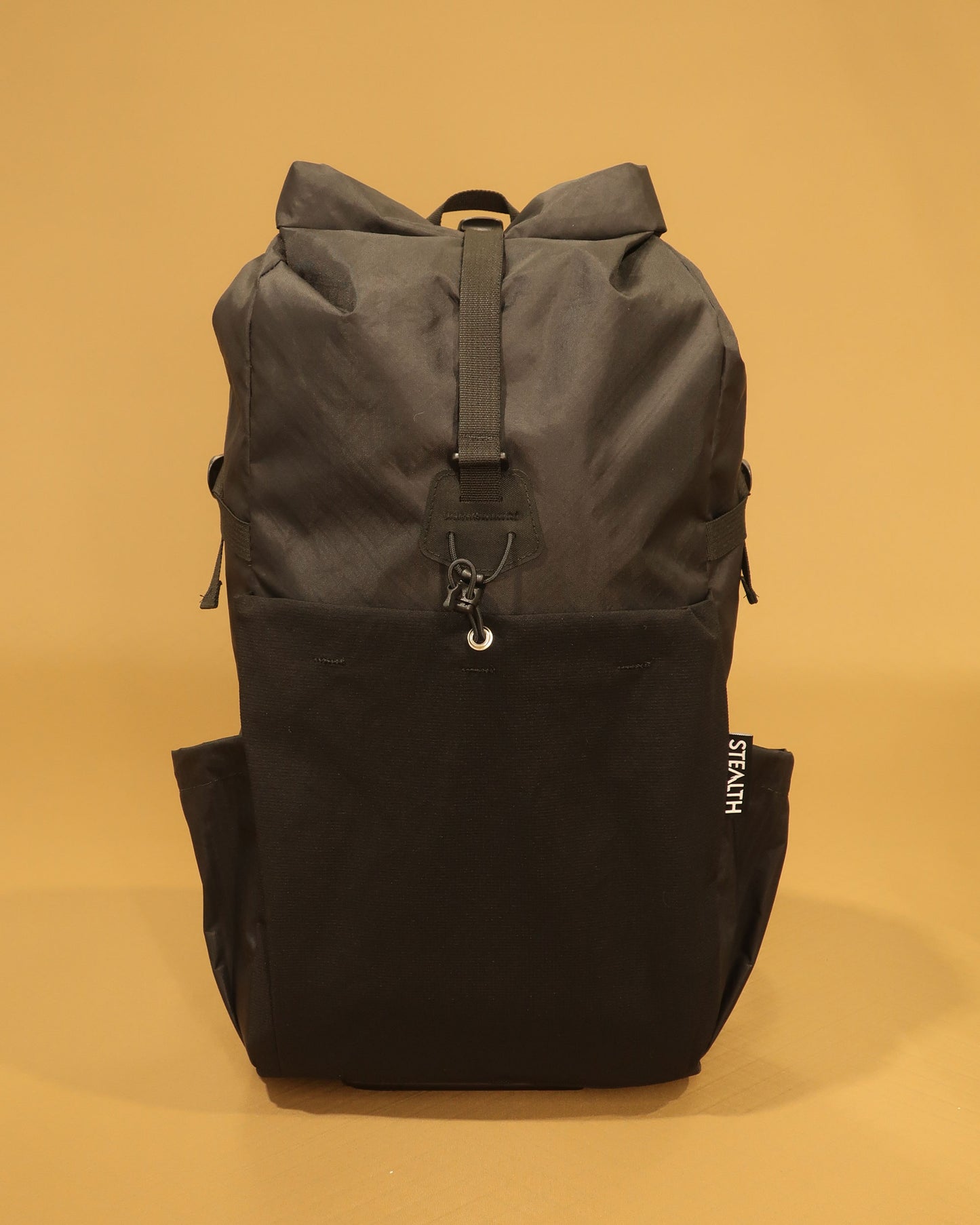 Rata 25 black roll-top daypack front view with ultrastretch pocket and compression strap made by Stealth Wellington NZ