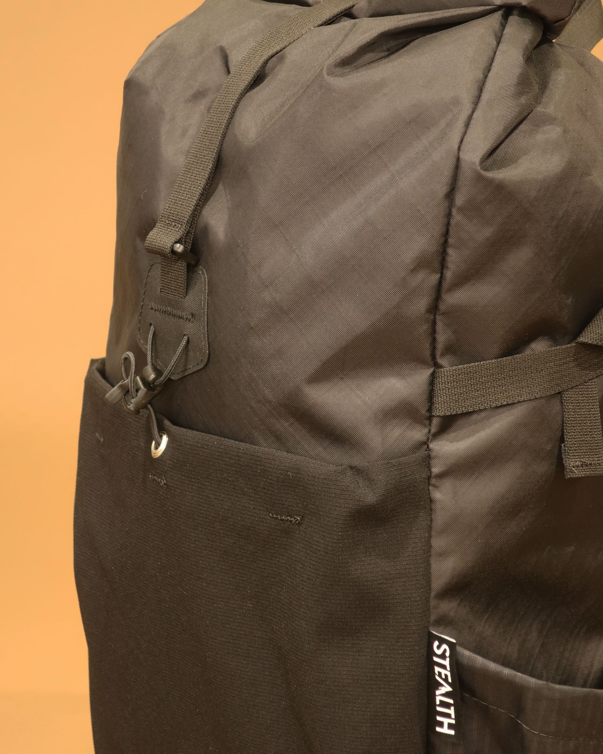 Rata 25 backpack detail showing ultrastretch front pocket and compression strap made by Stealth Wellington NZ