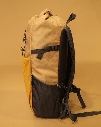 Rata 25 roll-top pack in coyote side profile showing ultragrid bottle pocket and compression strap made by Stealth Wellington NZ