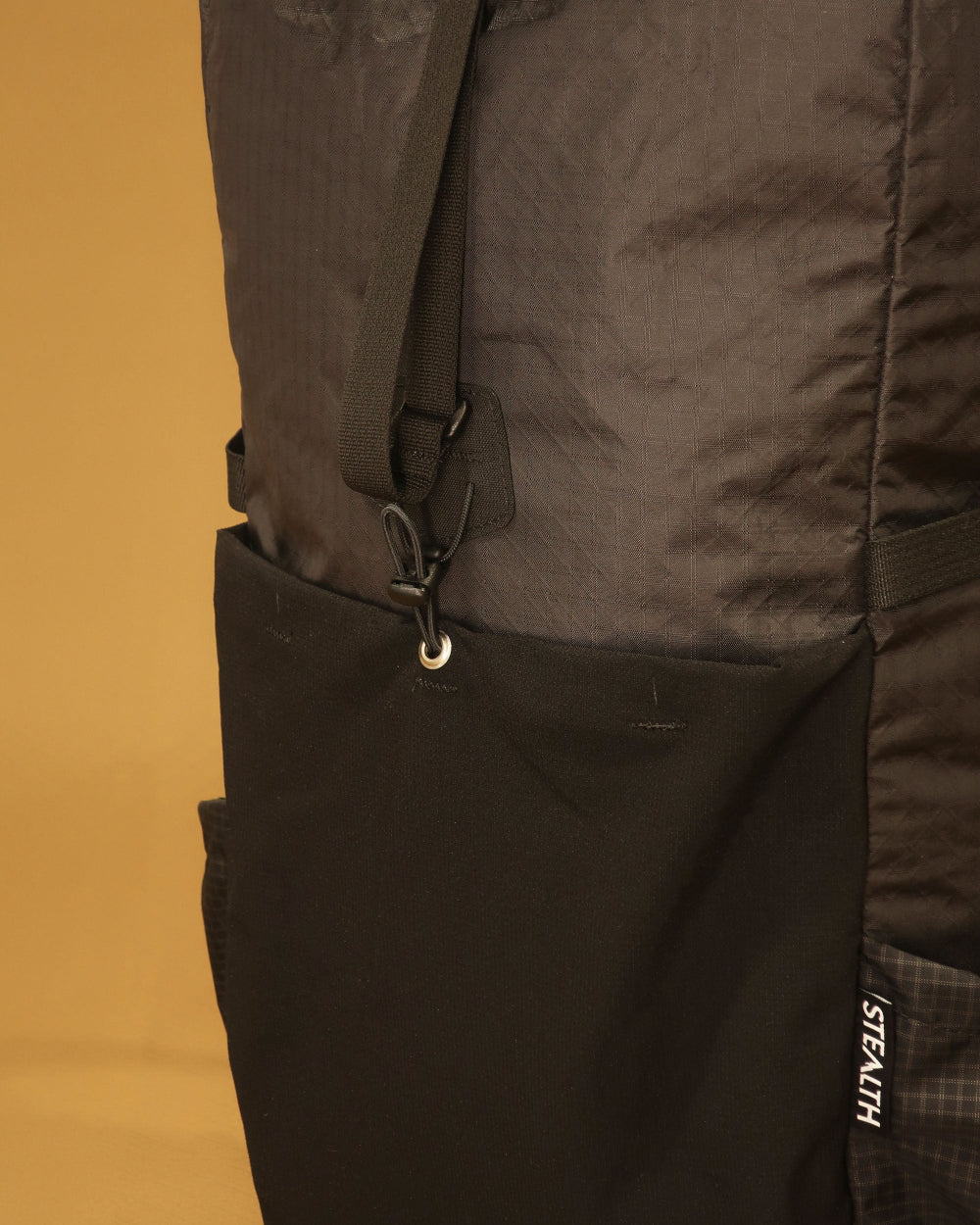 40L tramping pack ultra-stretch front pocket and compression strap detail in black, made by Stealth Wellington NZ
