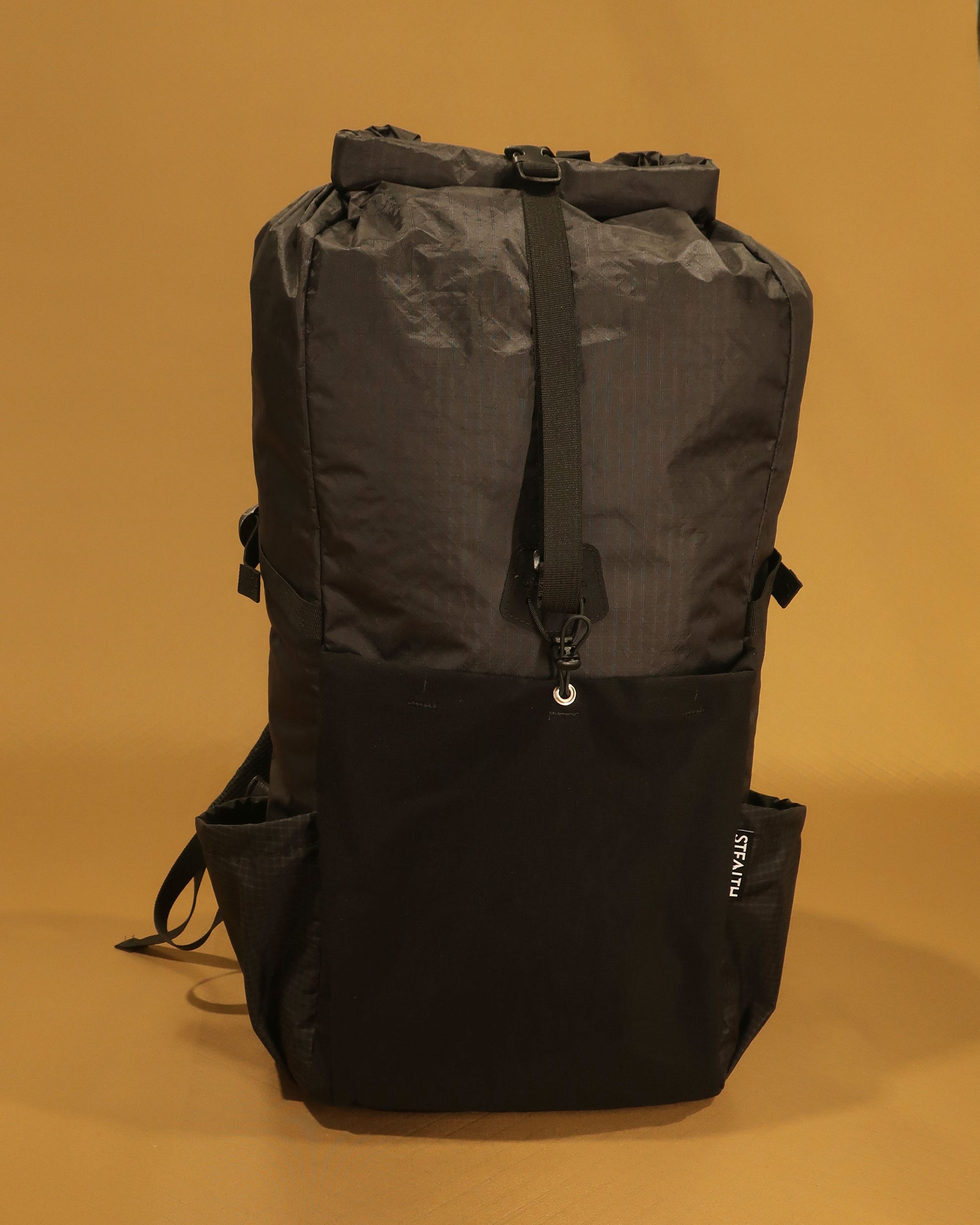 Black overnight tramping pack showing ultra-stretch front pocket with compression strap, made by Stealth Wellington NZ
