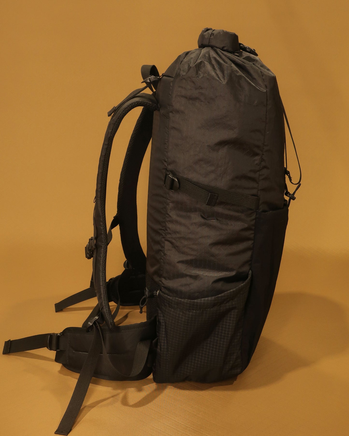 Rata 40 lightweight tramping pack in black showing Ultragrid side bottle pocket and hip belt, made by Stealth Wellington NZ