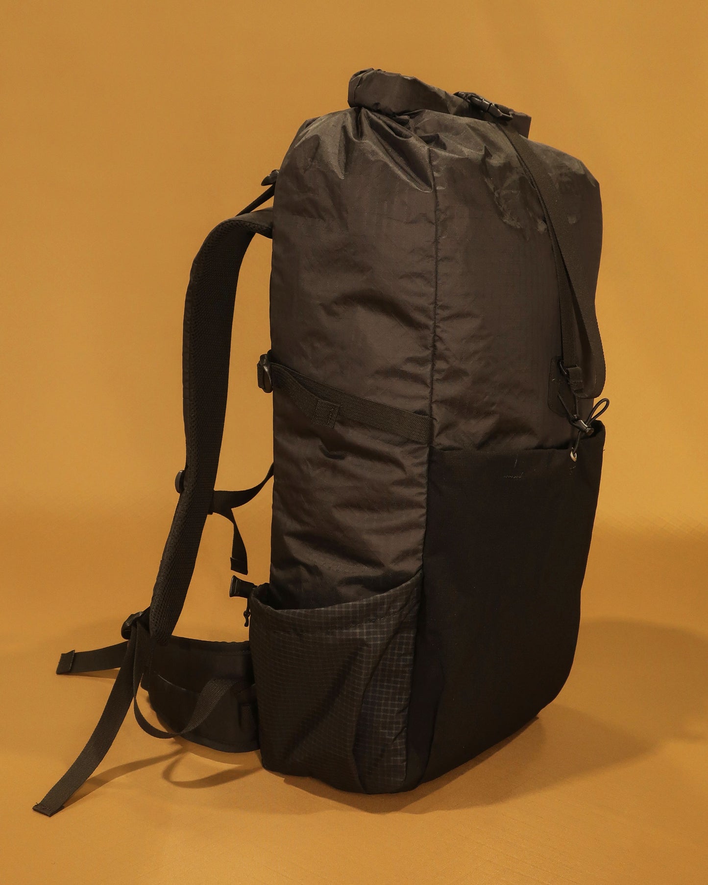 Black 40L hiking pack showing ultra-stretch front pocket and Ultragrid side bottle pocket, made by Stealth Wellington NZ