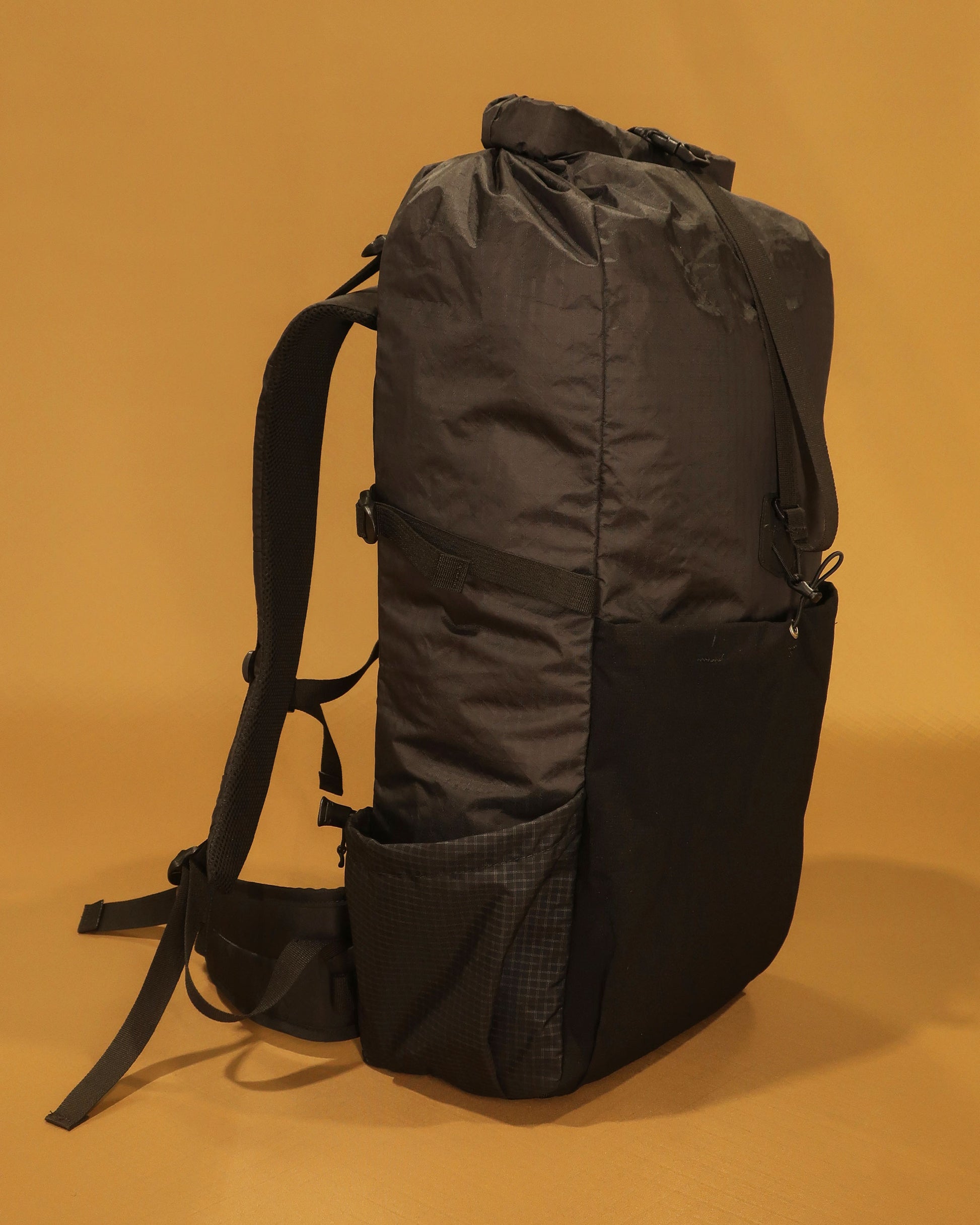 Black 40L hiking pack showing ultra-stretch front pocket and Ultragrid side bottle pocket, made by Stealth Wellington NZ