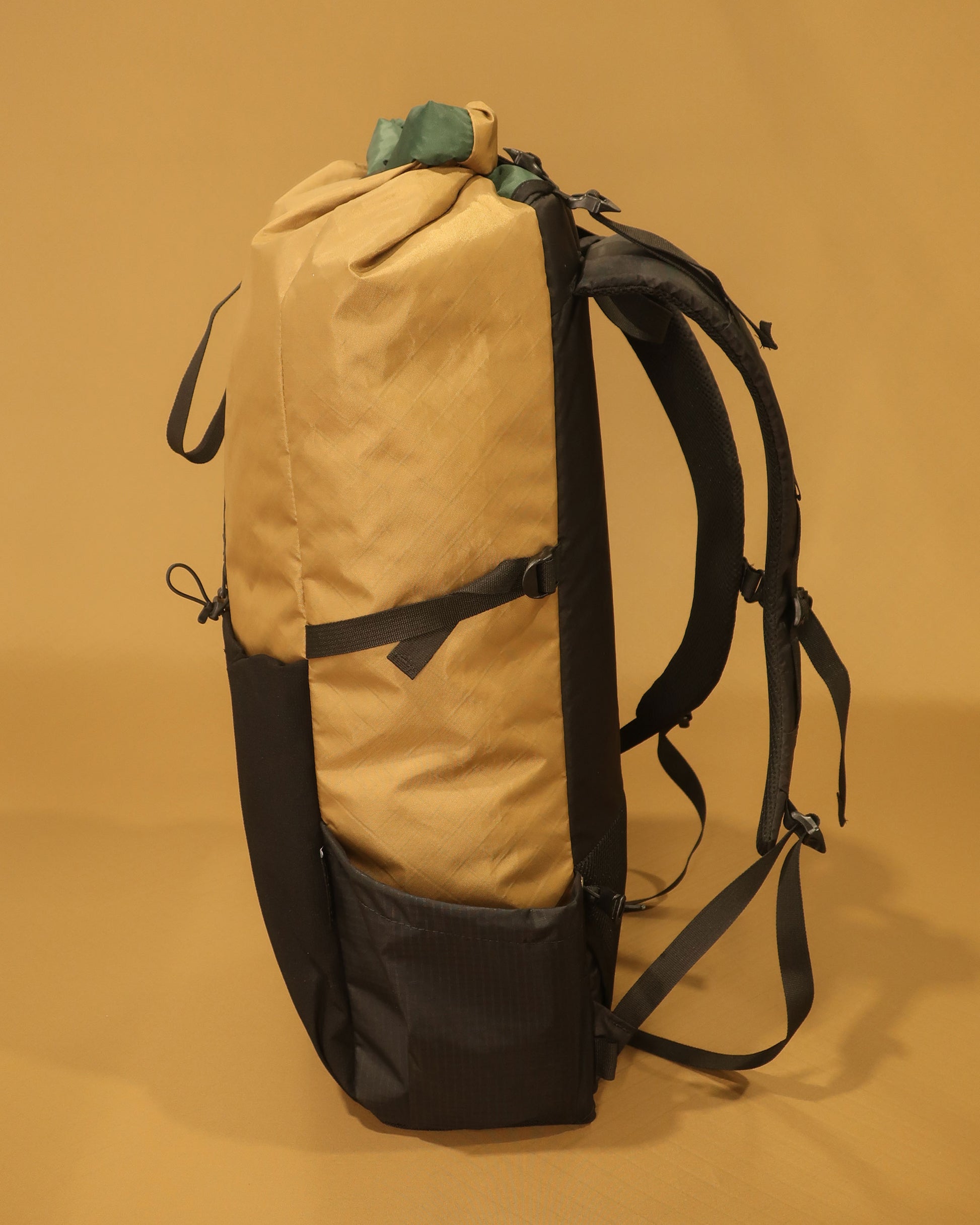Coyote Rata 40 ultralight pack side view showing Ultragrid bottle pocket and compression strap, made by Stealth Wellington
