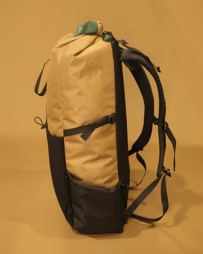 Coyote Rata 40 ultralight pack side view showing Ultragrid bottle pocket and compression strap, made by Stealth Wellington