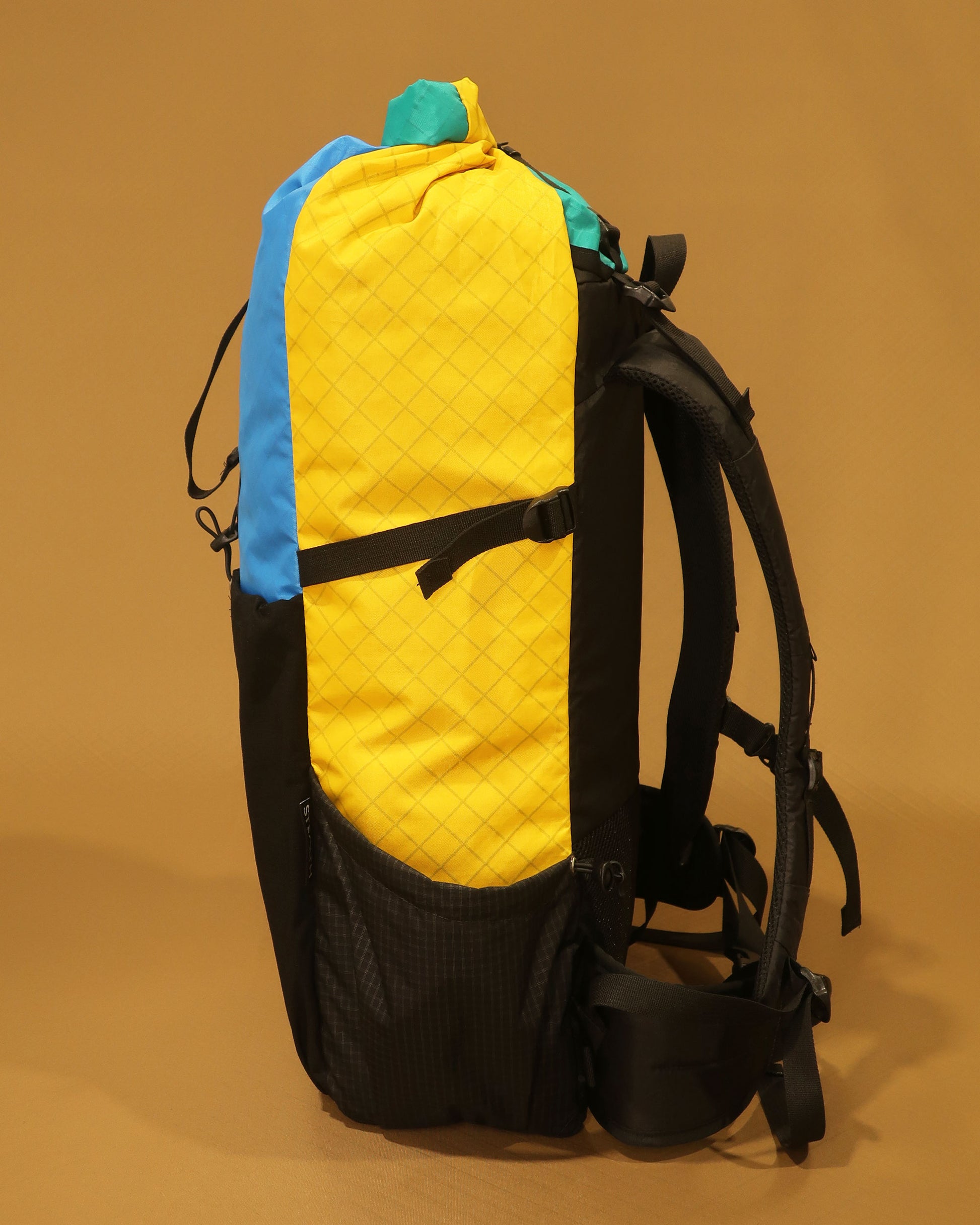 EPX200 Ecopak 40L tramping pack side profile showing compression strap and Ultragrid side pocket, made by Stealth Wellington NZ