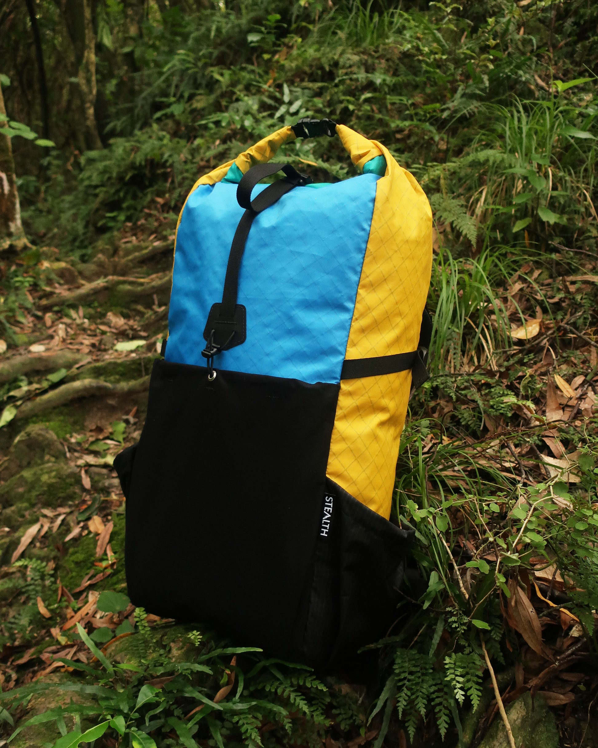 Rata 40 tramping pack in NZ native bush, multicolour blue yellow and teal Ecopak version, made by Stealth Wellington NZ
