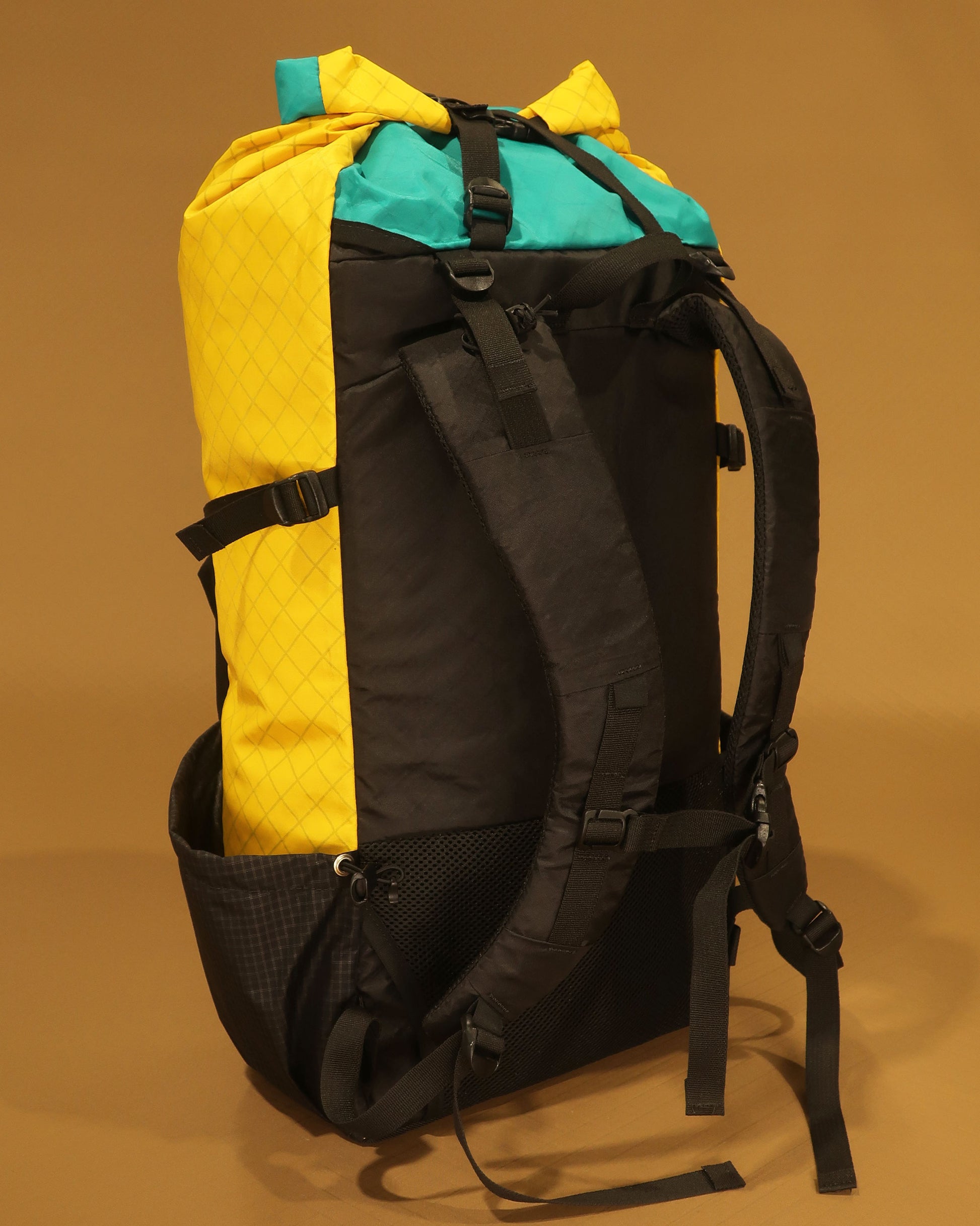 Lightweight tramping pack with removable hip belt shown detached, yellow Ecopak version, made by Stealth Wellington NZ