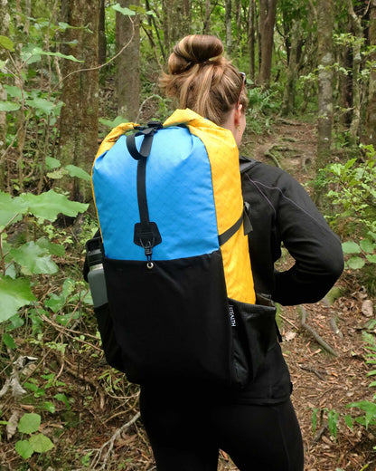 Rata 40 multicolour EPX200 overnight tramping pack worn by female hiker on NZ bush trail, made by Stealth Wellington NZ