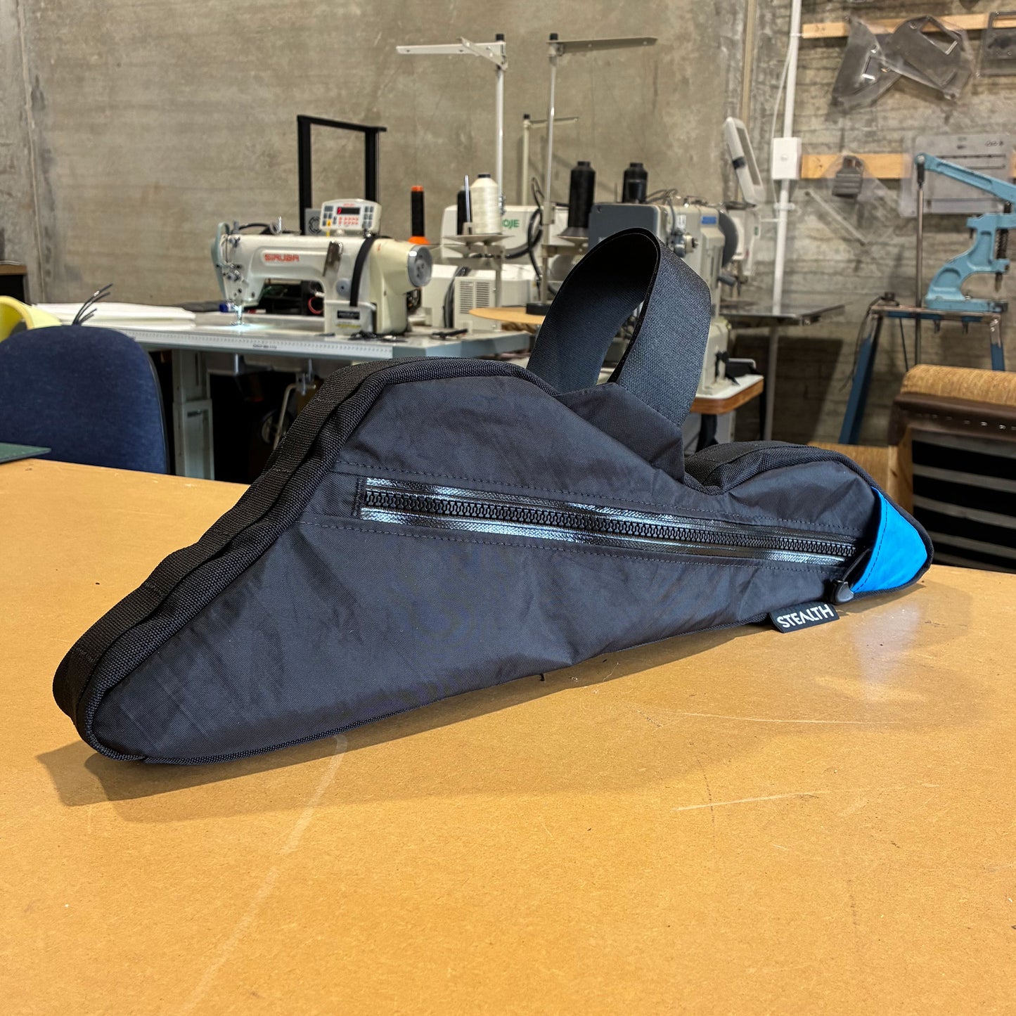 Black bikepacking frame bag with single zipper and blue accent, designed for full suspension mountain bikes.