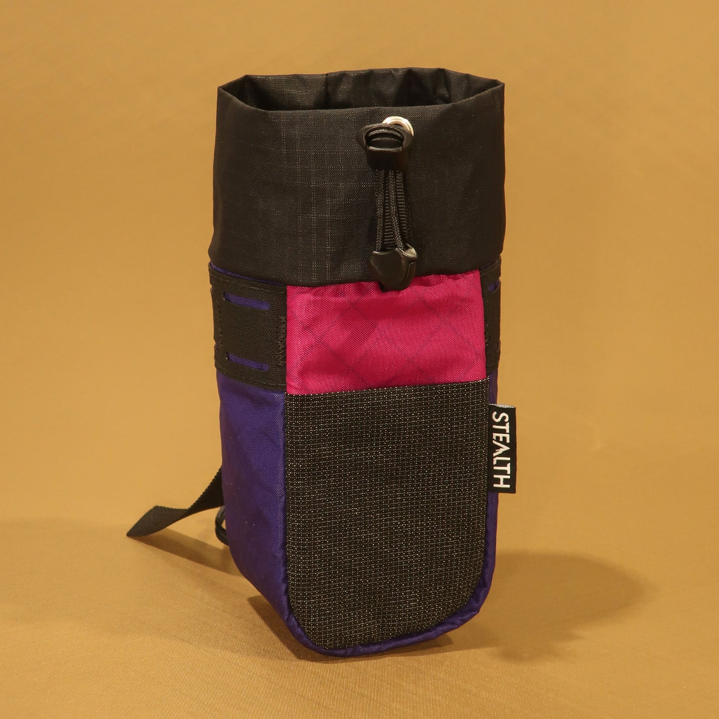 Stem Pouch V2 purple pouch with a black drawcord closure, pink stretch front pocket, and mesh panel.