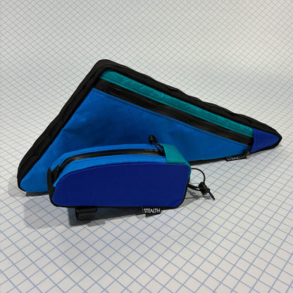 Blue custom bikepacking frame bag with single zipper and matching top tube bag, designed for durable outdoor cycling gear.